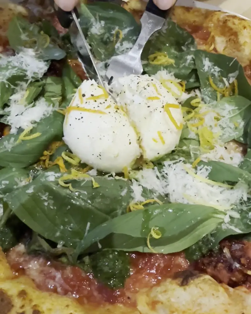 Cutting a burrata pizza
